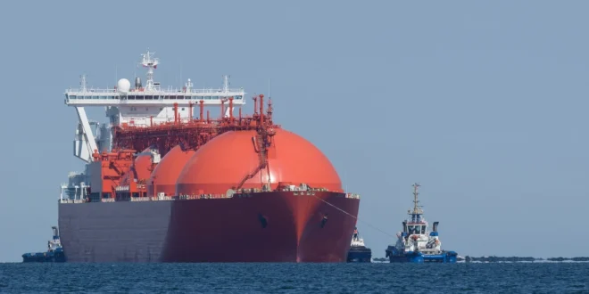 A liquified natural gas tanker and tugs sail to the terminal.Shutterstock