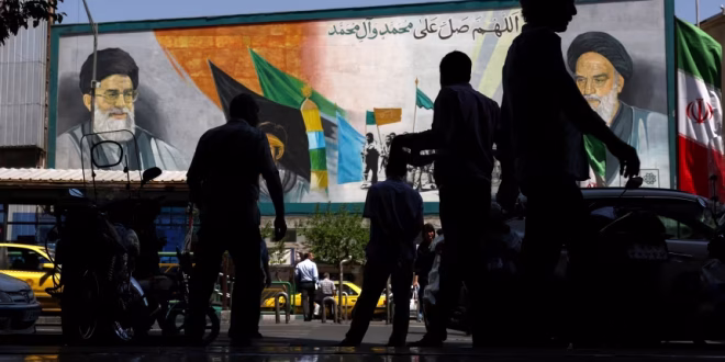 People walk past a mural depicting the late leader of the Islamic Revolution, Ayatollah Ruhollah Khomeini, and the late Iran's Supreme Leader Ayatollah Ali Khamenei, in Tehran, Iran, May 12, 2026. Majid Asgaripour/WANA/Reuters